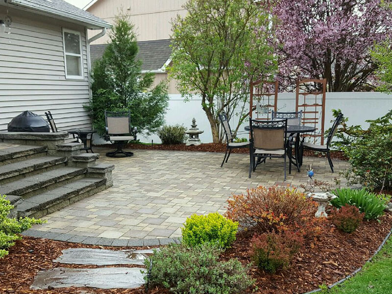 Front yard landscape with curved mulch beds, shrubs and a paver patio installed by Elite Hardscapes in Spokane, WA