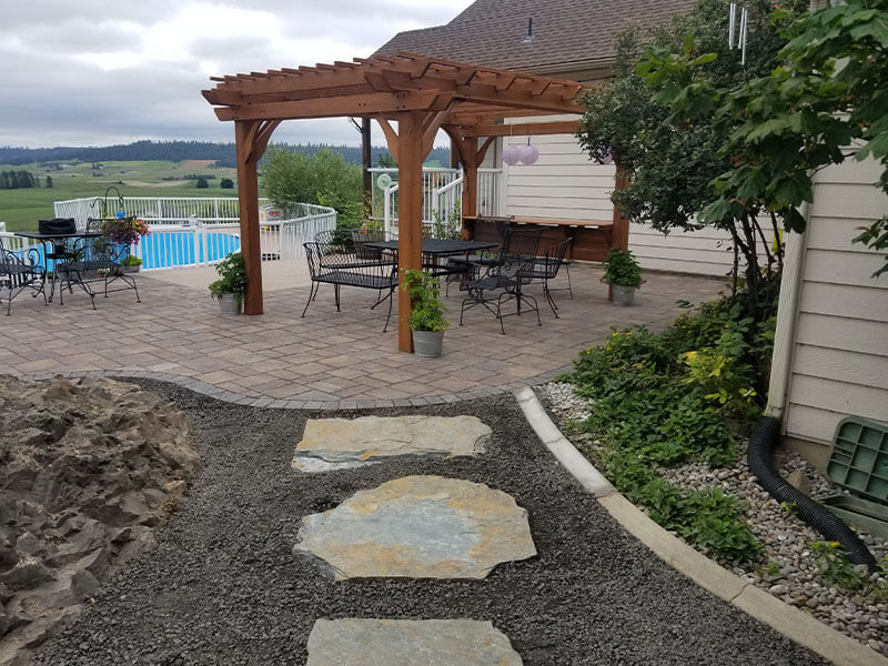 Cedar pergola over a paver patio with outdoor seating, built by Elite Hardscapes in Spokane, WA