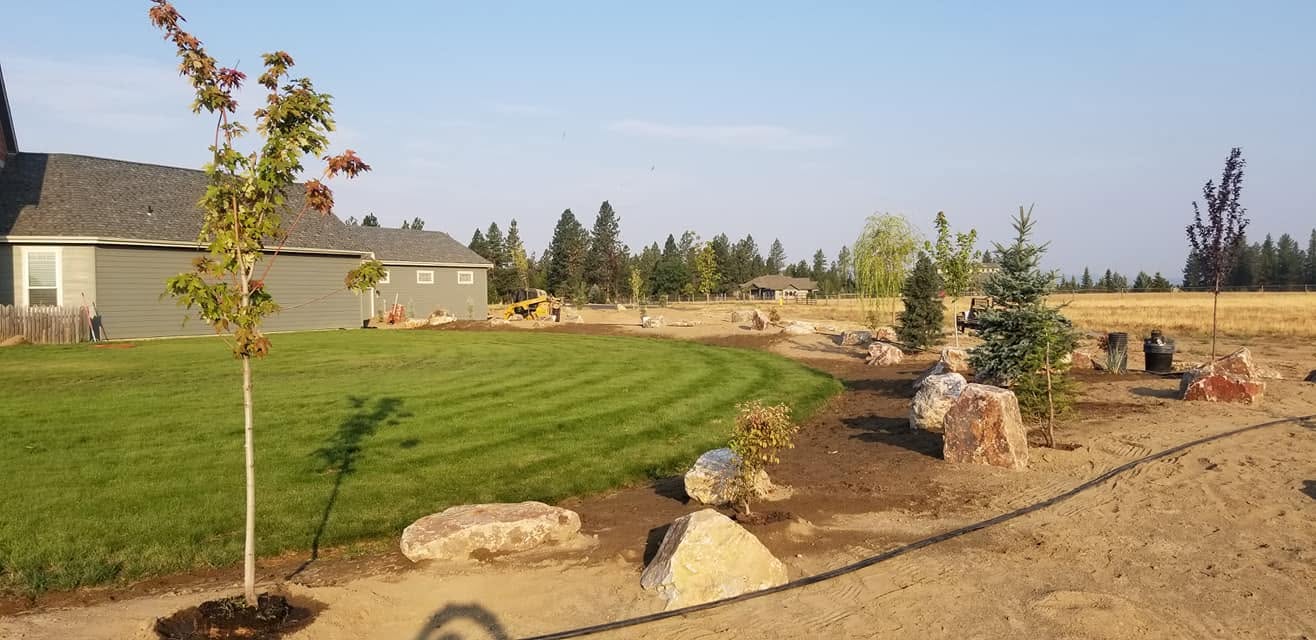 Pop-up sprinkler head watering a green lawn on a Spokane property, installed by Elite Hardscapes
